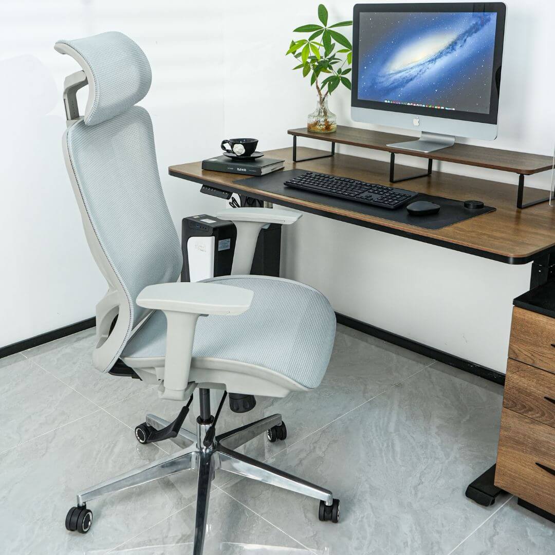 Picture of a standing desk setup with a gray mesh ergonomic chair